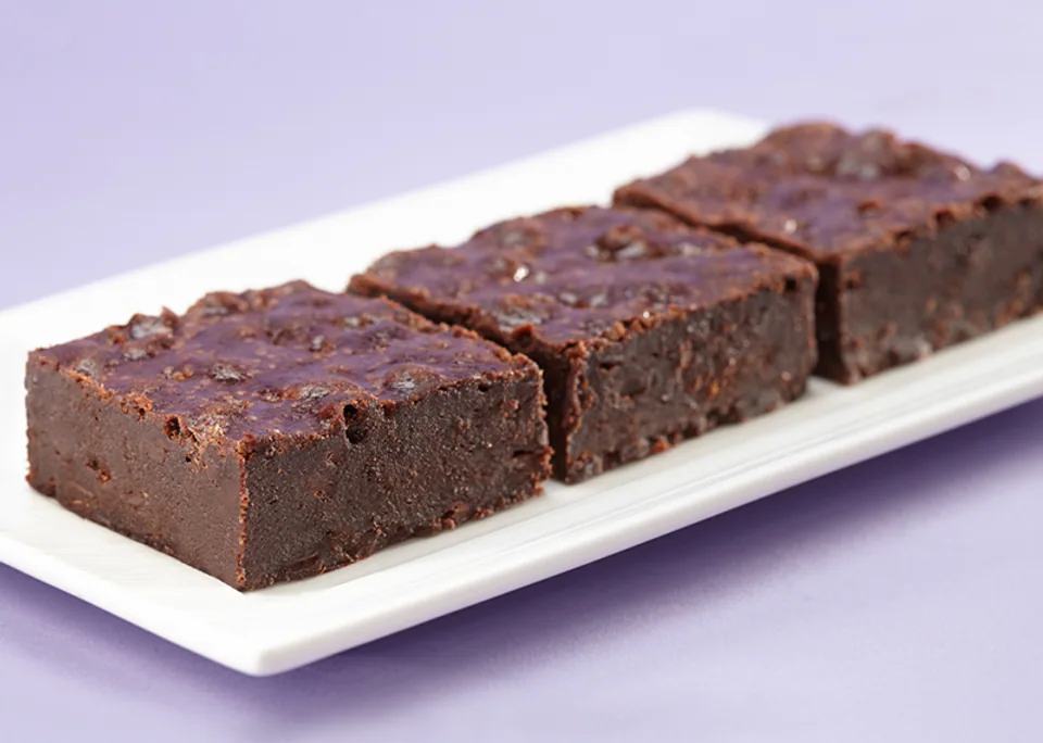 Three fudgy chocolate brownies on a white plate