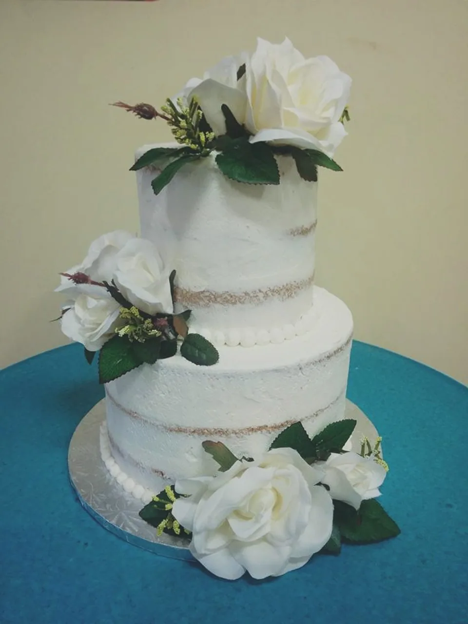 Two-tier naked cake with white roses