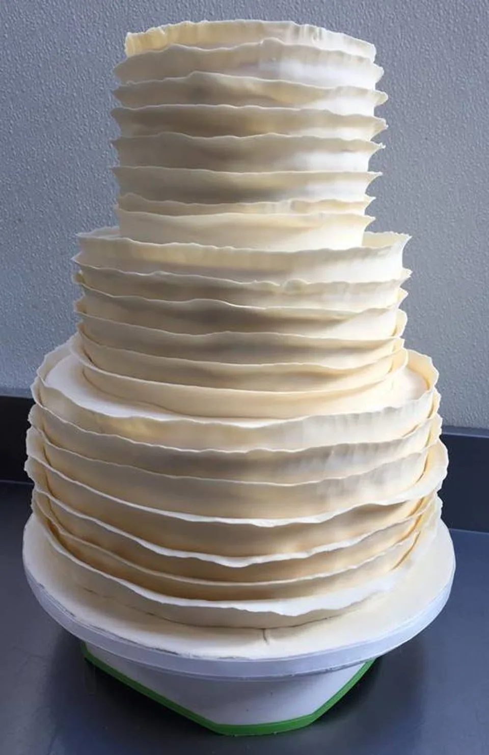 Three-tier white ruffled buttercream wedding cake
