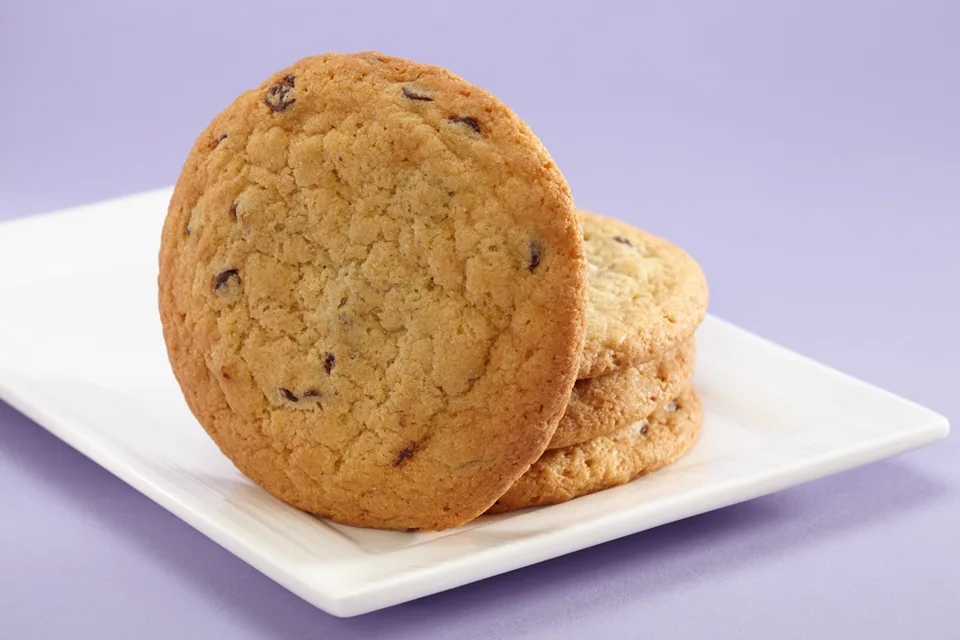 Two chocolate chip cookies on a white plate