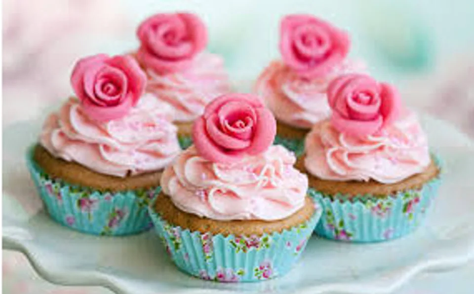 Pink rose-topped cupcakes on a platter