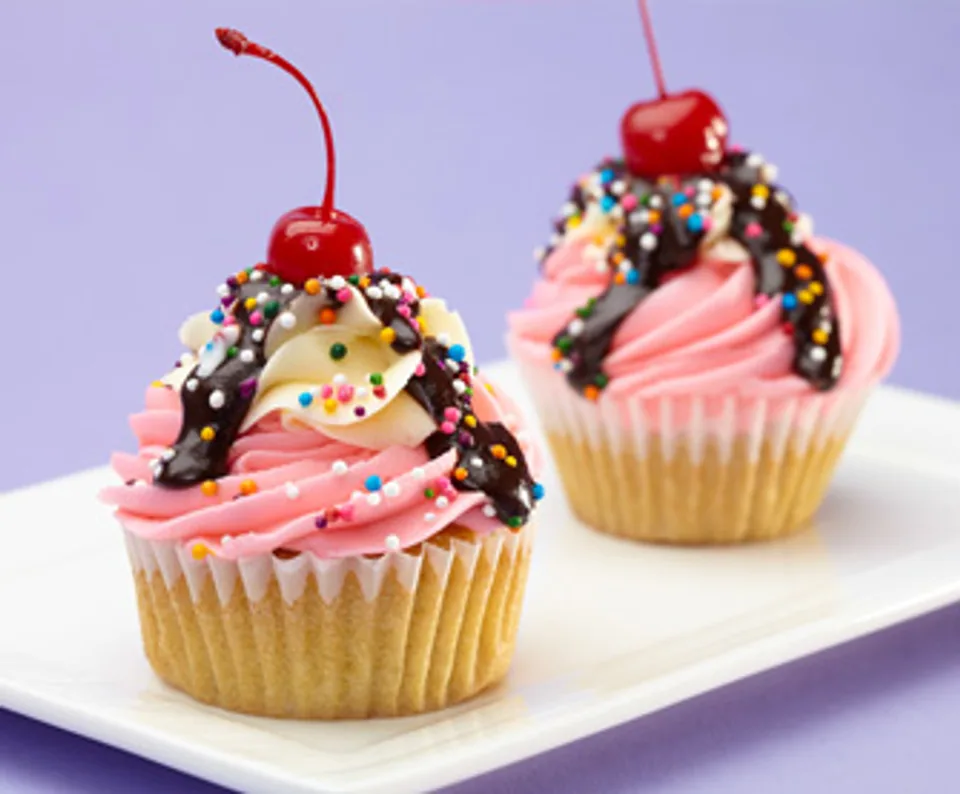 Pink and chocolate frosted cupcakes topped with cherries