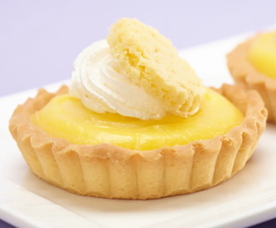 Lemon tart with whipped cream and a lemon slice