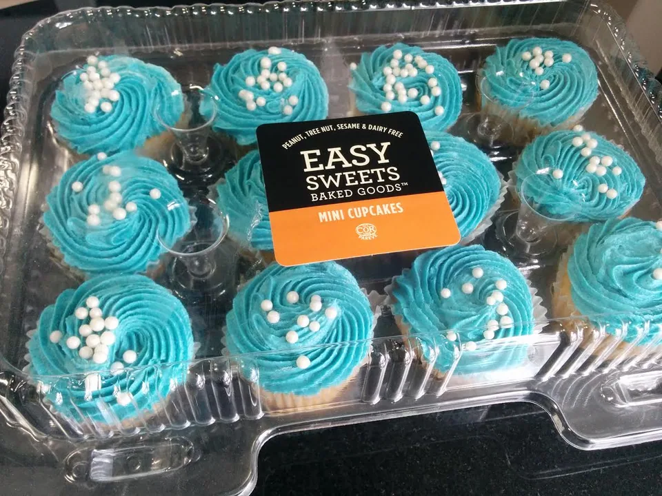 Mini blue frosted cupcakes with white sprinkles in a clear package