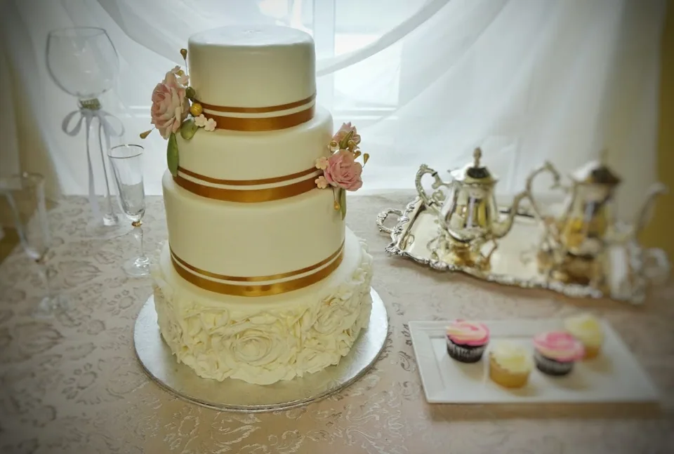 Wedding sweet table with tiered cake, macarons and gold accents